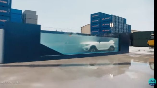 Volvo XC40 Recharge diturunkan pakai katrol ke tangki berisi air dengan salah satu sisi tembus pandang [YouTube: WapCar].