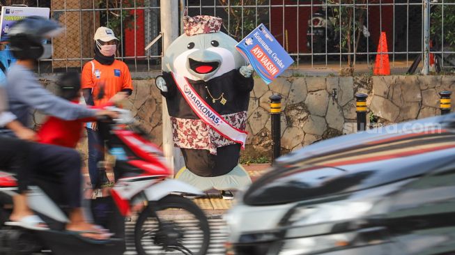 Maskot Hari Konsumen Nasional (Harkonas) Si Enda melakukan aksi kampanye kepada pengendara di kawasan Tugu Tani, Jakarta Pusat, Selasa (3/8/2021). [Suara.com/Alfian Winanto]