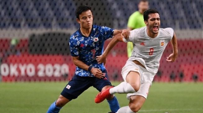 Pemain Jepang Takefusa Kubo melanggar pemain Spanyol dalam pertandingan semifinal Olimpiade Tokyo di Saitama Stadium, Selasa (3/8/2021). [AFP]