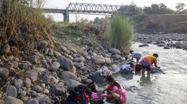 Warga mencuci pakaian di aliran Sungai Cipamingkis yang menyusut di Jonggol, Kabupaten Bogor, Jawa Barat, Selasa (3/8/2021).  ANTARA FOTO/Yulius Satria Wijaya