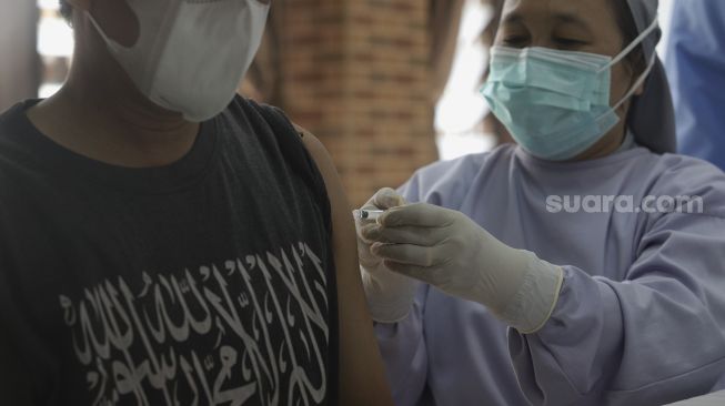 Vaksinator menyuntikkan vaksin COVID-19 kepada warga di Yayasan St Fransiskus Asisi, Jakarta, Selasa (3/8/2021). [Suara.com/Angga Budhiyanto]