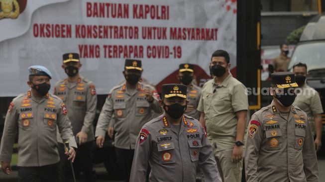 Kapolri Jenderal Polisi Listyo Sigit Prabowo (tengah) bersiap memberikan keterangan saat pelepasan bantuan 1.000 oksigen konsentrator untuk warga yang terpapar COVID-19 di Mabes Polri, Jakarta, Selasa (3/8/2021). [Suara.com/Angga Budhiyanto] 