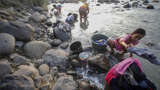 Warga mencuci pakaian di aliran Sungai Cipamingkis yang menyusut di Jonggol, Kabupaten Bogor, Jawa Barat, Selasa (3/8/2021).  ANTARA FOTO/Yulius Satria Wijaya