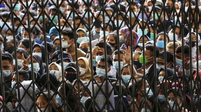 Warga antre untuk melakukan vaksinasi di aula Gedung Serbaguna Pemprov Sumatera Utara, Kota Medan, Selasa (3/8/2021). [ANTARA FOTO/Fransisco Carolio]