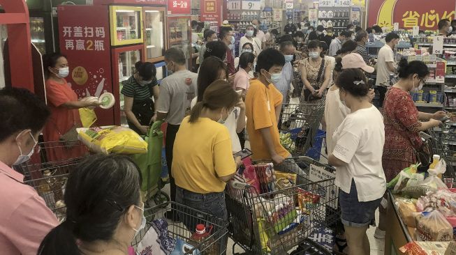 Orang-orang membeli barang di supermarket di Wuhan, Provinsi Hubei, China, pada (2/8/2021). [STR / AFP]