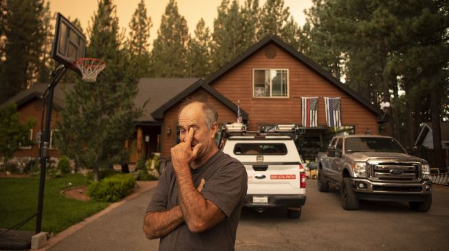 Warga yang kehilangan rumah bereaksi ketika petugas penegak hukum memberi tahu penduduk tentang perintah evakuasi saat kebakaran di Dixie, Greenville, California, pada (3/8/2021). [JOSH EDELSON / AFP]