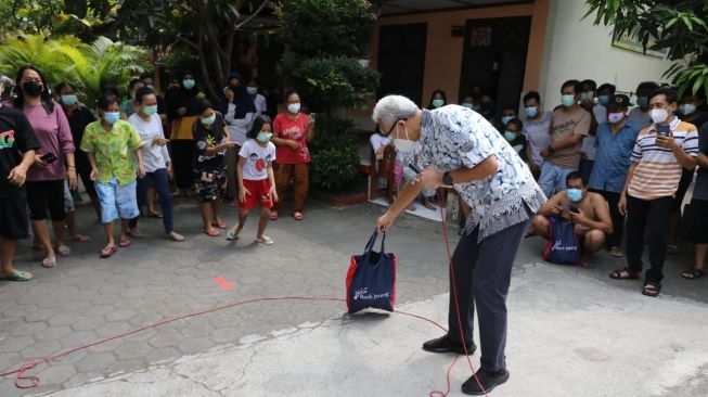 Gubernur Jawa Tengah Ganjar Pranowo dan Wali Kota Solo Gibran Rakabuming Raka saat mengunjungi pasien Covid-19 yang diIsolasi di SD Cemara Solo. [Dok Pemprov Jateng]