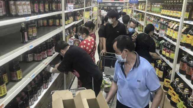 Orang-orang membeli barang di supermarket di Wuhan, Provinsi Hubei, China, pada (2/8/2021). [STR / AFP]