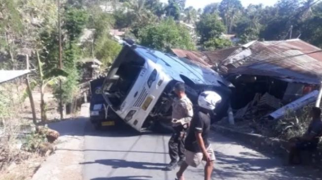 Bus Damri Pengantar Jenazah Pendeta Terbalik Hantam Rumah Warga