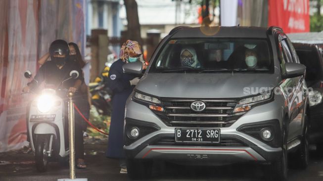 Suasana jalannya proses vaksinasi Covid-19 warga secara Drive Thru di Polres Metro Jakarta Selatan, Kamis (5/8/2021) . [Suara.com/Alfian Winanto]