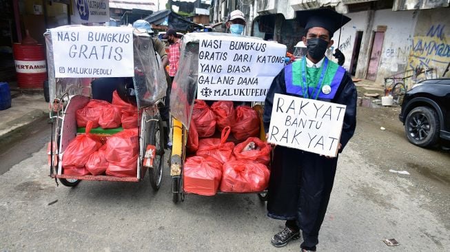 Seorang mahasiswa yang baru selesai wisuda bersama komunitas Maluku Peduli menunjukkan becak berisi ratusan nasi bungkus untuk dibagikan kepada warga di Pasar Batu Merah, Kota Ambon, Maluku, Kamis (5/8/2021).  ANTARA FOTO