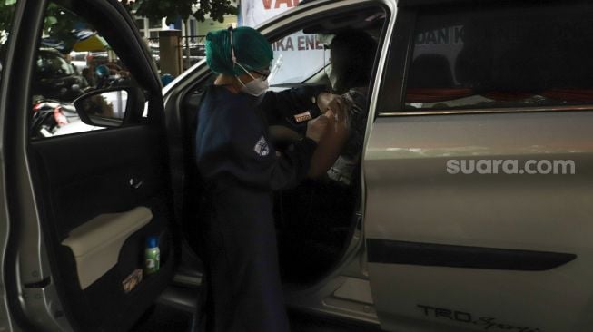 Warga saat menjalani proses vaksinasi Covid-19 secara Drive Thru di Polres Metro Jakarta Selatan, Kamis (5/8/2021) . [Suara.com/Alfian Winanto]