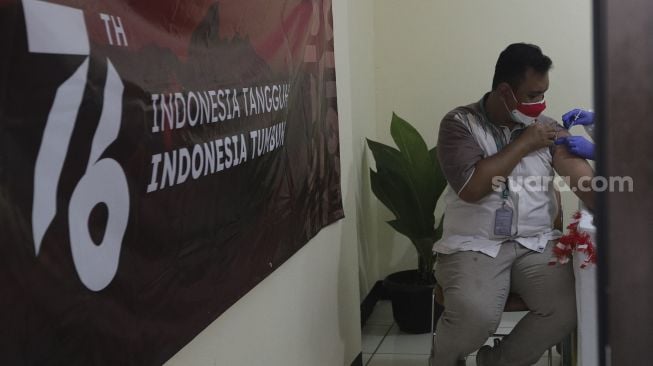 Vaksinator menyuntikkan vaksin COVID-19 dosis ketiga atau booster kepada tenaga kesehatan di Rumah Sakit Umum Daerah (RSUD) Matraman, Jakarta, Jumat (6/8/2021). [Suara.com/Angga Budhiyanto]