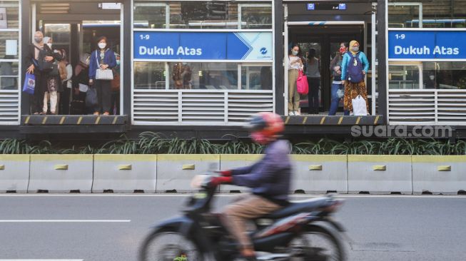 Penumpang menunggu Bus Transjakarta di halte Transjakarta Dukuh Atas, Jakarta Pusat, Jumat (6/8/2021). [Suara.com/Alfian Winanto]