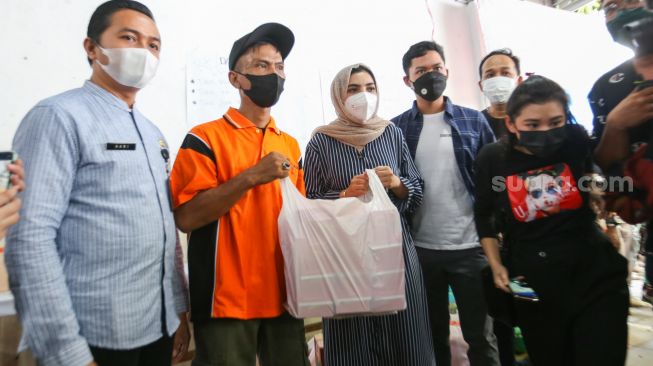 Aktris Ashanty memberikan bantuan berupa sembako kepada warga korban kebakaran di Jalan Karet Pasar Baru 1, Karet Tengsin, Jakarta Pusat, Jumat (6/8/2021). [Suara.com/Alfian Winanto]