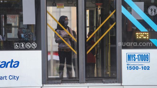 Penumpang menunggu Bus Transjakarta di halte Transjakarta Dukuh Atas, Jakarta Pusat, Jumat (6/8/2021). [Suara.com/Alfian Winanto]