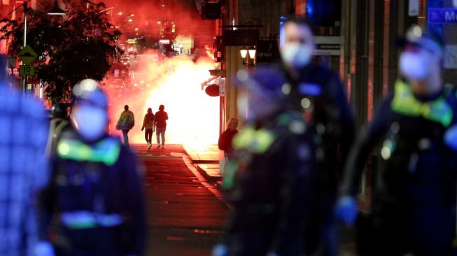 Pengunjuk rasa menyalakan suar ketika memprotes perpanjangan lockdown atau penguncian ketat di Melbourne, Australia, Kamis (5/8/2021).  [AFP Foto]
