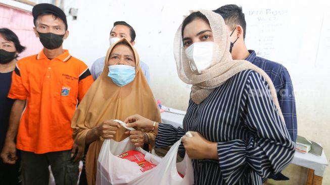 Aktris Ashanty memberikan bantuan berupa sembako kepada warga korban kebakaran di Jalan Karet Pasar Baru 1, Karet Tengsin, Jakarta Pusat, Jumat (6/8/2021). [Suara.com/Alfian Winanto]