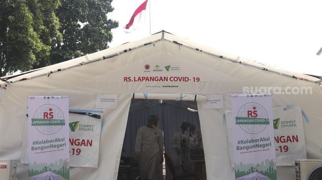 Petugas medis menangani pasien di tenda darurat yang dijadikan ruang triase di halaman RSUD Matraman, Jakarta, Jumat (6/8/2021). [Suara.com/Angga Budhiyanto]