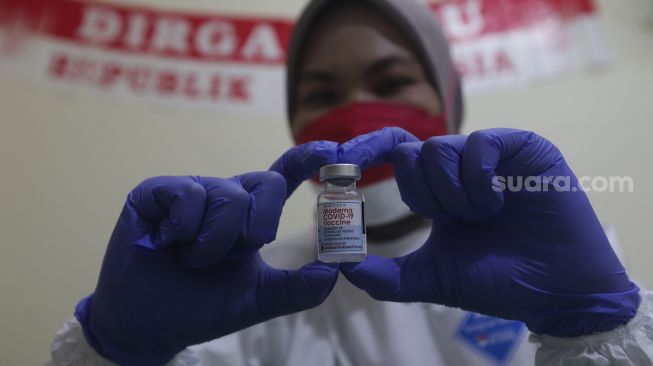 Vaksinator menunjukkkan vaksin COVID-19 Moderna yang akan disuntikkan kepada tenaga kesehatan di Rumah Sakit Umum Daerah (RSUD) Matraman, Jakarta, Jumat (6/8/2021). [Suara.com/Angga Budhiyanto]