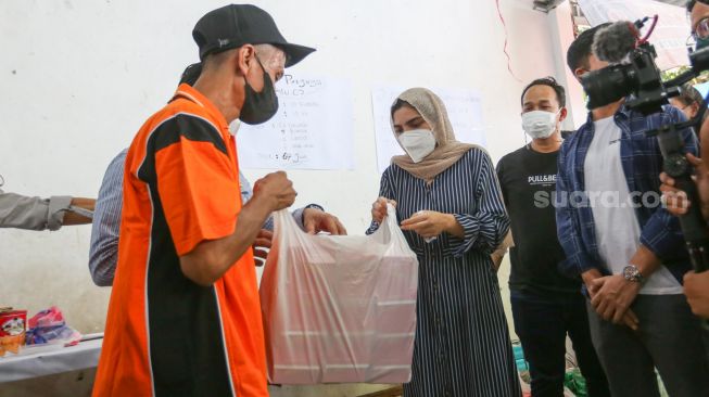 Aktris Ashanty memberikan bantuan berupa sembako kepada warga korban kebakaran di Jalan Karet Pasar Baru 1, Karet Tengsin, Jakarta Pusat, Jumat (6/8/2021). [Suara.com/Alfian Winanto]