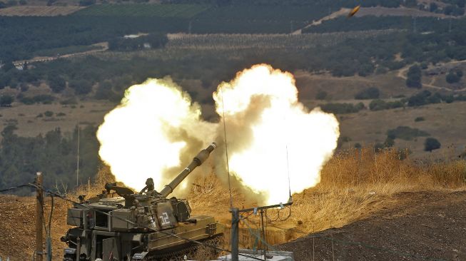 Howitzer self-propelled Israel menembak ke arah Lebanon dari posisi dekat kota Kiryat Shmona di Israel Utara, menyusul tembakan roket dari sisi perbatasan Lebanon, pada (6/8/2021). [JALAA MAREY / AFP]