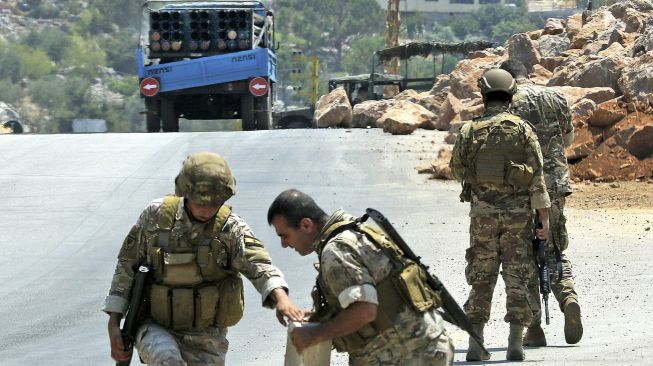 Tentara Lebanon berdiri di samping sebuah truk yang membawa peluncur roket ganda, di desa selatan Shouayya, Lebanon, pada (6/8/2021). [Mahmoud ZAYYAT / AFP]