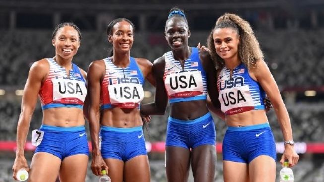 Kuarter pelari putri Amerika Serikat Sydney McLaughlin, Allyson Felix, Dalilah Muhammad dan Athing Mu, membentangkan bendera Amerika Serikat setelah menyabet medali emas estafet 4x400 meter putri di Olympic Stadium, Tokyo, Jepang, 7 Agustus 2021. [AFP]