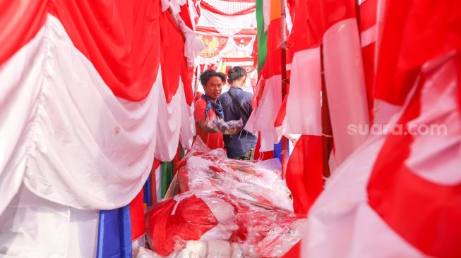 Pedagang bendera merah putih dan pernak-pernik 17 an menjajakan dagangannya di Jalan Matraman Raya, Jatinegara, Jakarta Timur, Minggu (8/8/2021). [Suara.com/Alfian Winanto]