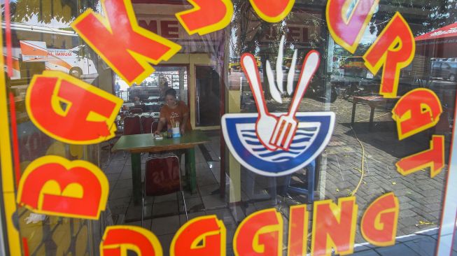 Pekerja merapikan meja salah satu rumah makan di Terminal Kalideres, Jakarta, Sabtu (7/8/2021). ANTARA FOTO/Rivan Awal Lingga