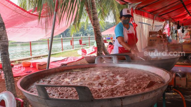 Petugas menyiapkan masakan di dapur umum Kementerian Sosial di Gedung Konvensi, Taman Makam Pahlawan (TMP) Kalibata, Jakarta, Minggu (8/8/2021). [Suara.com/Alfian Winanto]