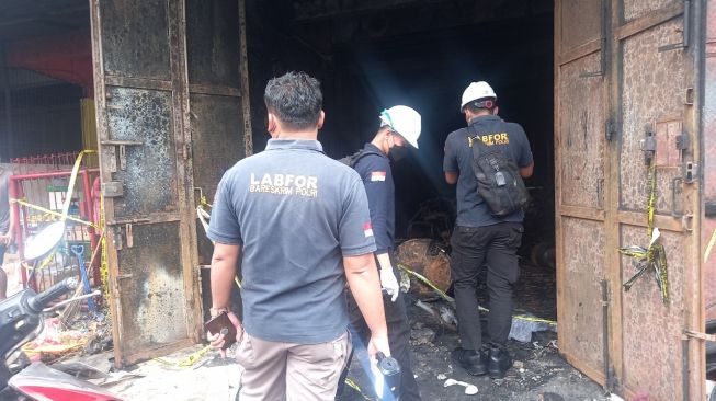 Personel Puslabfor Polri memeriksa lokasi kebakaran bengkel di Cibodas, Kota Tangerang. [SuaraBanten.id/Muhammad Jehan Nurhakim]