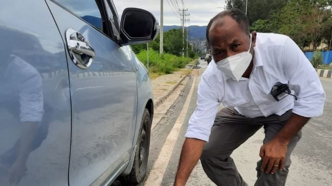 Ketua Komnas HAM Papua, Frits B Ramandey melakukan olah TKP perusakan mobil Ketua AJI Jayapura, Senin (9/8/2021). (Dok. Komnas HAM Papua)