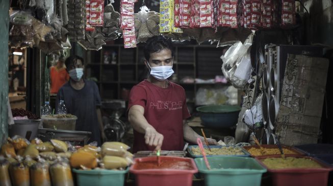 Pedagang bumbu giling menunggu datangnya pembeli di Pasar Palmerah, Jakarta, Senin (9/8/2021). ANTARA FOTO/Dhemas Reviyanto