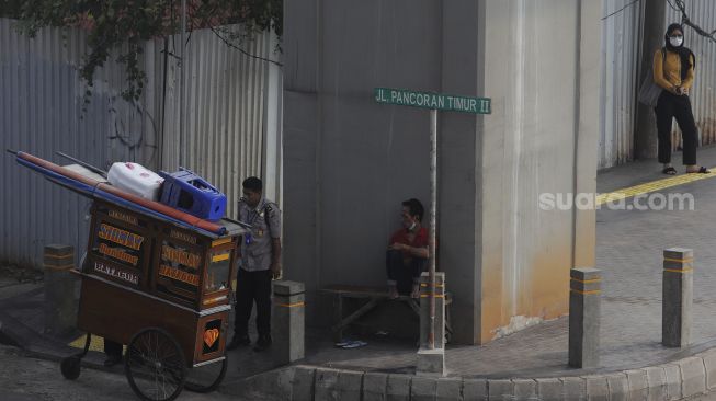 Pedagang menjajakan dagangannya di Jalan Pancoran Timur II, Jakarta, Senin (9/8/2021). [Suara.com/Angga Budhiyanto]