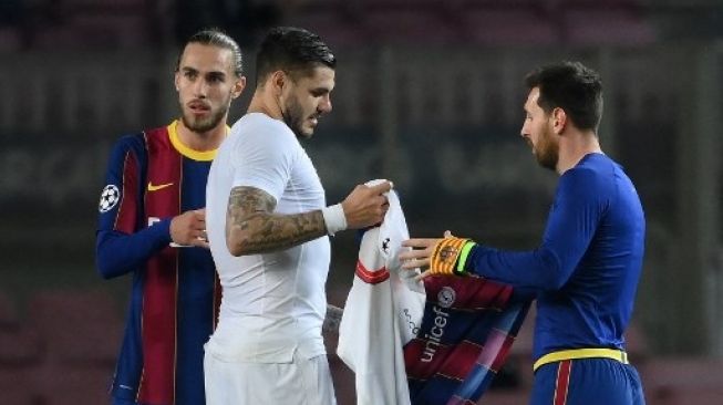 Mauro Icardi dan Lionel Messi saat bertukar jersey di laga PSG vs Barcelona di Liga Champions musim lalu. (LLUIS GENE / AFP)