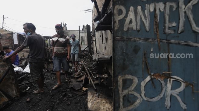 Warga mencari barang yang masih bisa digunakan pascakebakaran di kawasan Grogol Petamburan, Jakarta, Selasa (10/8/2021). [Suara.com/Angga Budhiyanto]