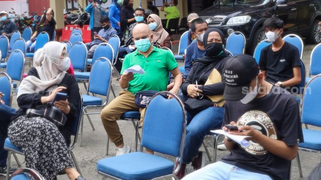 Aktor Ozy Syahputra saat mengantri bersama warga lainnya untuk menjalani vaksinasi Covid-19 di Polsek Tebet, Jakarta Selatan, Selasa (10/8/2021). [Suara.com/Alfian Winanto]