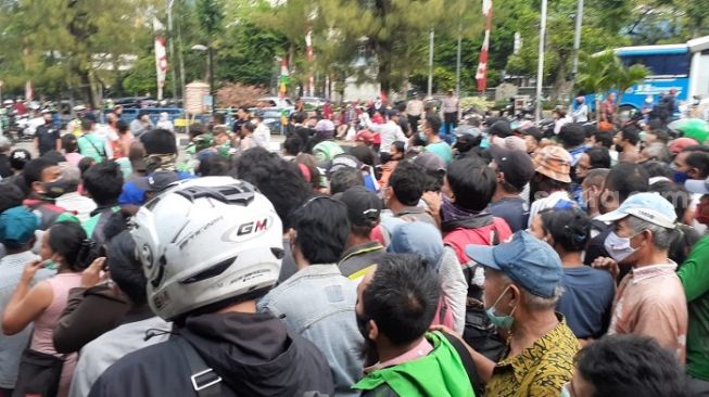 Warga berkerumun saat Presiden Jokowi membagi-bagikan sembako di Terminal Grogol, Jakbar. (Suara.com/Yaumal)