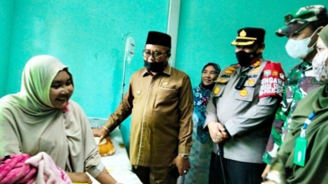 Bupati Aceh Barat Haji Ramli MS bersama Kapolres AKBP Andrianto Argamuda SIK, Dandim 0105 Aceh Barat Letkol Inf Dimar Bahtera membesuk AW, mahasiswi yang diduga lumpuh setelah disuntik vaksin Covid-19. [ANTARA]