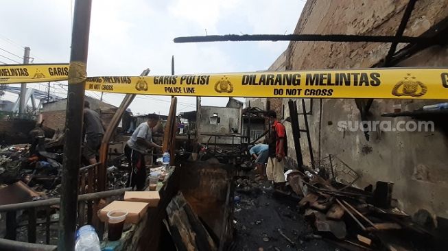 Warga di Jalan Muwardi Raya, Grogol Petamburan, Jakarta Barat saat membersihkan puing-puing sisa kebakaran yang menghanguskan rumah mereka. (Suara.com/Yaumal)