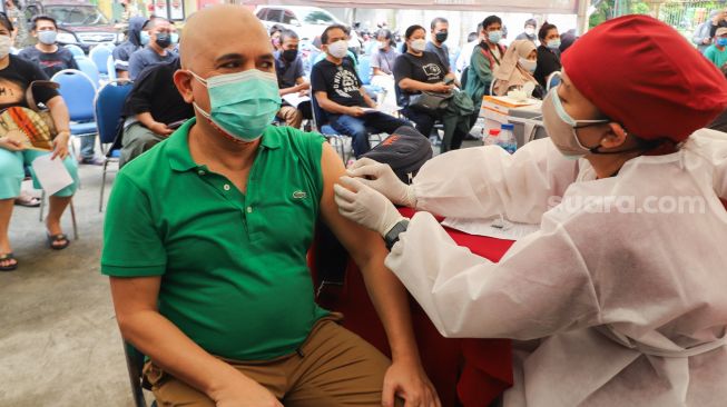 Aktor Ozy Syahputra saat menjalani vaksinasi Covid-19 di Polsek Tebet, Jakarta Selatan, Selasa (10/8/2021). [Suara.com/Alfian Winanto]