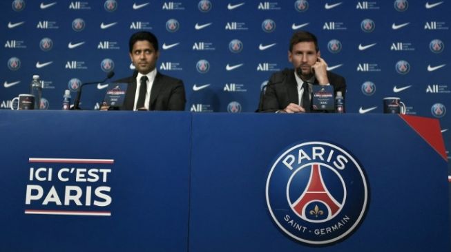 Penyerang Argentina, Lionel Messi saat berbicara dalam konferensi pers perkenalannya sebagai pemain baru Paris Saint-Germain (PSG) di Stadion Parc des Princes, Paris, Rabu (11/8/2021) sore WIB. Dia ditemani  Presiden PSG Nasser Al Khelaifi. [AFP].