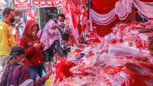 Warga belanja ornamen dan pernak-pernik bendera merah putih di Pasar Jatinegara, Jakarta Timur, Rabu (11/8/2021). [Suara.com/Alfian Winanto]