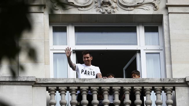 
Pesepak bola Lionel Messi menyapa penggemarnya dari balkon hotel Royal Monceau, Paris, Prancis, Selasa (10/8/2021).  [AFP Photo]