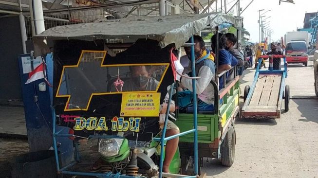 Kendaraan odong-odong mengangkut sejumlah warga Kampung Nelayan dan anak buah kapal yang beraktivitas di dermaga Pelabuhan Perikanan Muara Angke untuk menuju sentra vaksinasi COVID-19 di Rumah Susun Buddha Tzu Chi Muara Angke, Penjaringan, Jakarta Utara, Rabu (11/8/2021). (ANTARA/ Abdu Faisal)