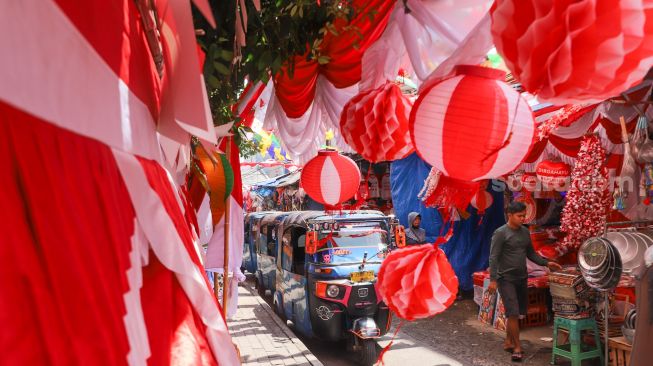 Suasana area pasar yang dipenuhi ornamen dan pernak-pernik bendera merah putih di Pasar Jatinegara, Jakarta Timur, Rabu (11/8/2021). [Suara.com/Alfian Winanto]