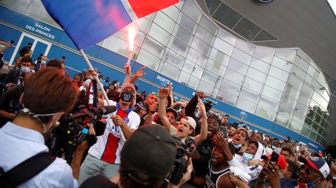 Fans PSG berkumpul dan bersorak di Parc des Princes menyambut kedatangan pemain anyar klub papan atas Liga Prancis itu, Lionel Messi, Selasa (10/8/2021).   [AFP Photo]