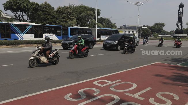 Sejumlah kendaraan melintas di Jalan Jenderal Sudirman, Jakarta, Rabu (11/8/2021). [Suara.com/Angga Budhiyanto]