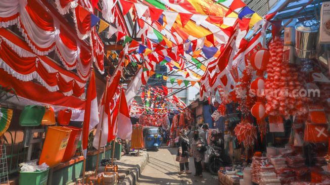 Suasana area pasar yang dipenuhi ornamen dan pernak-pernik bendera merah putih di Pasar Jatinegara, Jakarta Timur, Rabu (11/8/2021). [Suara.com/Alfian Winanto]